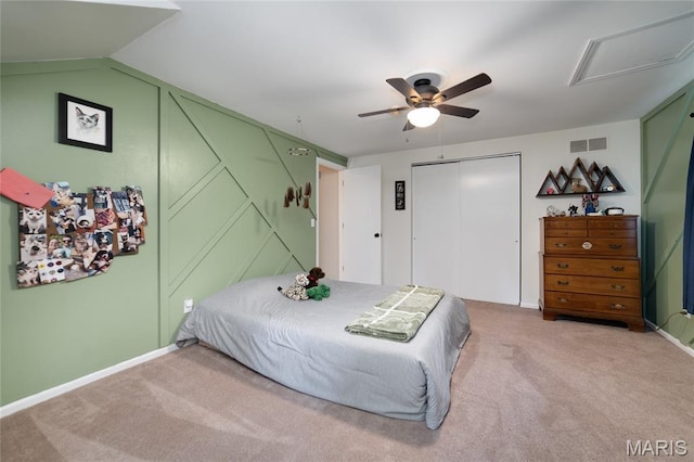 bedroom with light carpet, a closet, attic access, baseboards, and a ceiling fan