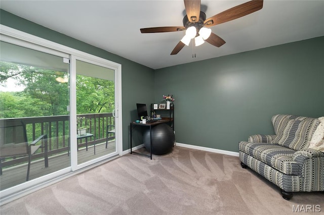 living area with carpet floors, baseboards, a ceiling fan, and a desk