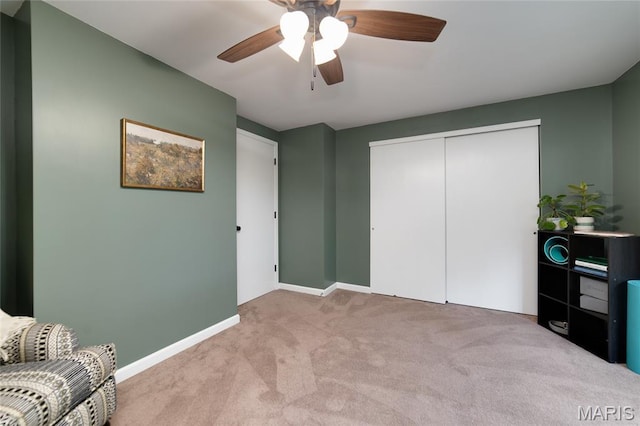 sitting room featuring carpet floors, baseboards, and ceiling fan