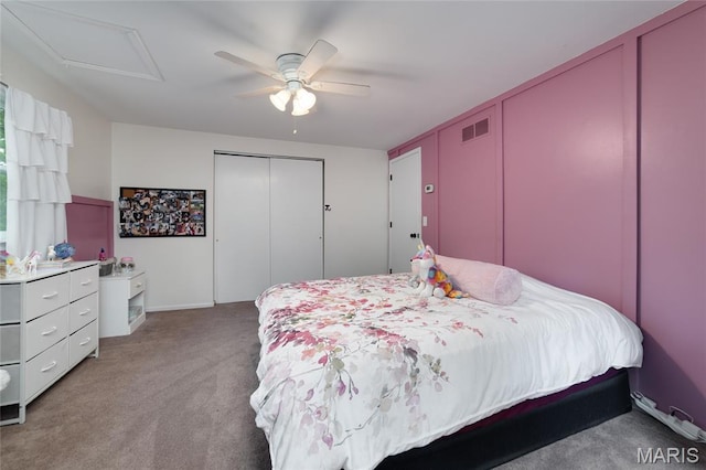 bedroom with light carpet, a ceiling fan, attic access, and baseboards