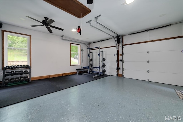 workout room with healthy amount of natural light, a ceiling fan, and a garage