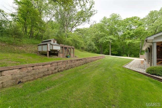 view of green lawn with an outbuilding and exterior structure