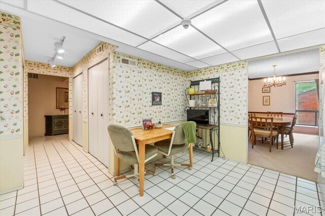 572 Coeur De Royale Dr Unit 105, Saint Louis, MO 63141 - dining room with wallpapered walls, a chandelier, a wainscoted wall, light tile patterned flooring, and a fireplace