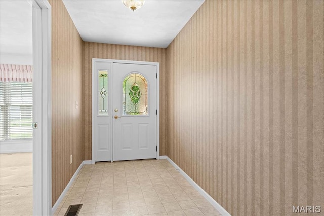 doorway with wallpapered walls and baseboards