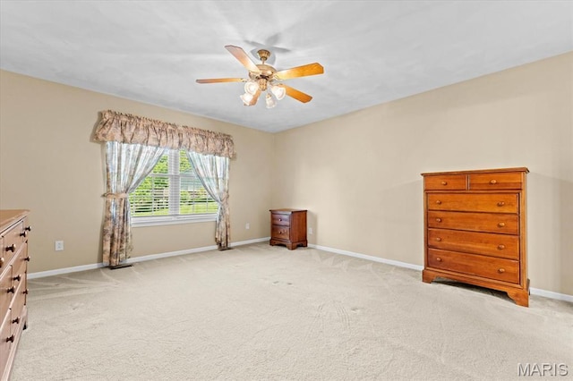 unfurnished bedroom featuring baseboards, light colored carpet, and a ceiling fan
