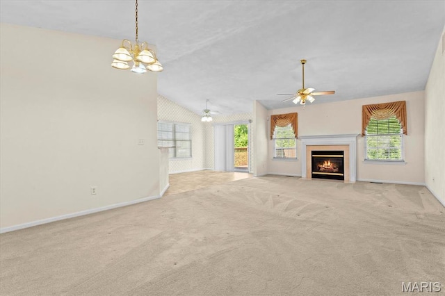 unfurnished living room with carpet, baseboards, healthy amount of natural light, a ceiling fan, and lofted ceiling