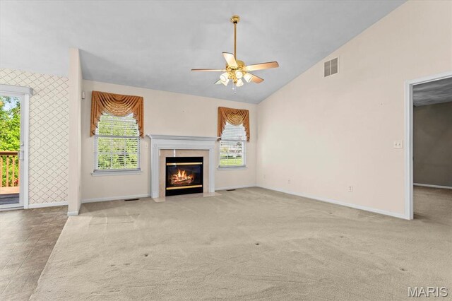 unfurnished living room with a ceiling fan, lofted ceiling, baseboards, a premium fireplace, and carpet