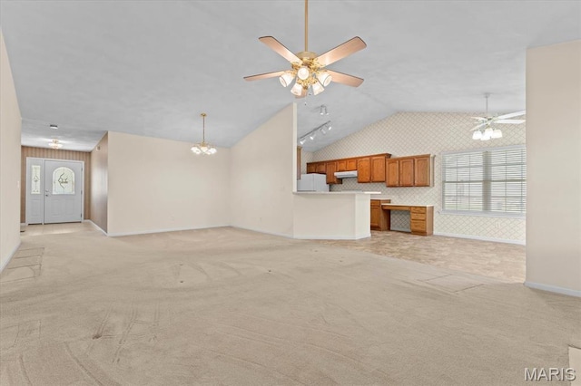 unfurnished living room with lofted ceiling, baseboards, light colored carpet, ceiling fan, and a chandelier