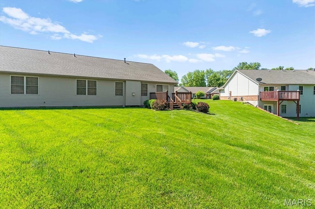 view of grassy yard with a deck