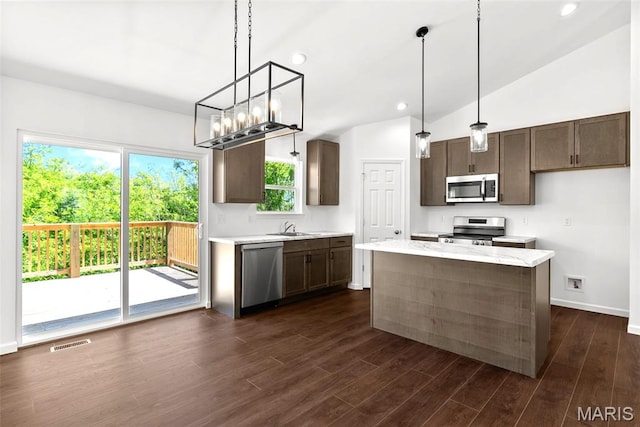 1909 Magnolia Way, Pevely, MO 63070 - kitchen with appliances with stainless steel finishes, vaulted ceiling, dark wood-style floors, dark brown cabinets, and decorative light fixtures