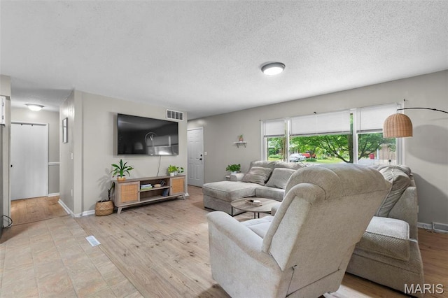804 Harvard St, Sikeston, MO 63801 - living room featuring light wood finished floors, baseboards, and a textured ceiling