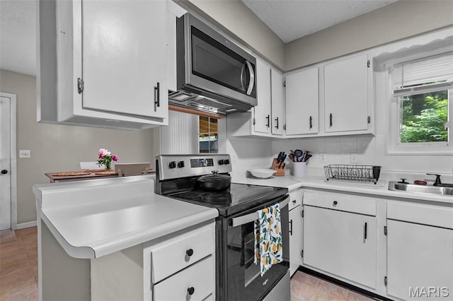804 Harvard St, Sikeston, MO 63801 - kitchen with appliances with stainless steel finishes, a sink, white cabinetry, light countertops, and plenty of natural light