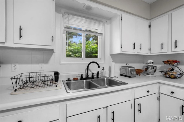 804 Harvard St, Sikeston, MO 63801 - kitchen featuring a sink, white cabinetry, and light countertops