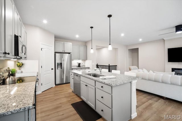 719 Myatt Dr, Wentzville, MO 63385 - kitchen featuring stainless steel appliances, open floor plan, light wood-style floors, light stone countertops, and recessed lighting