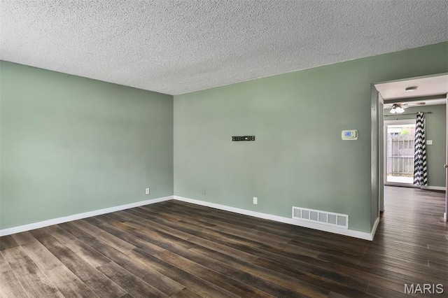 empty room with dark wood finished floors, baseboards, a textured ceiling, and a ceiling fan