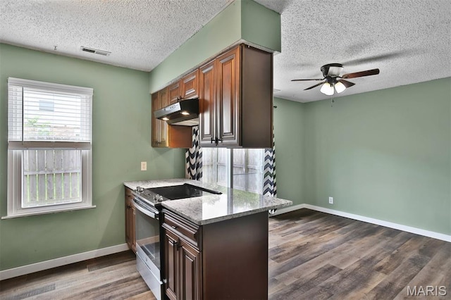 kitchen featuring stainless steel electric range, a textured ceiling, ceiling fan, under cabinet range hood, and dark wood-type flooring