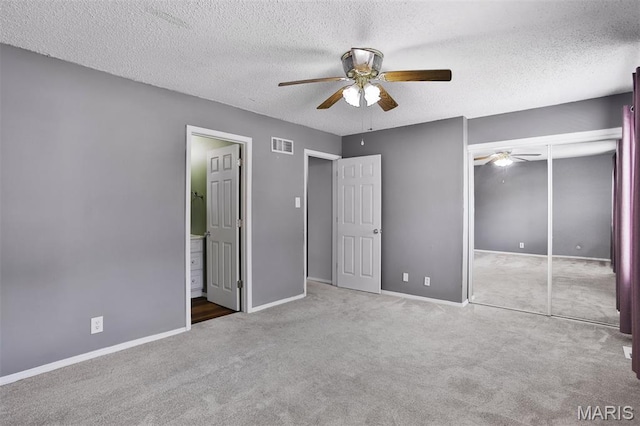 unfurnished bedroom with carpet, a textured ceiling, baseboards, a closet, and ceiling fan