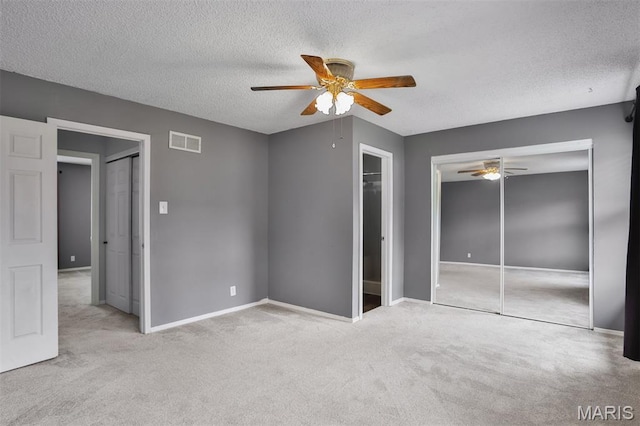 unfurnished bedroom featuring a textured ceiling, carpet, baseboards, and a ceiling fan