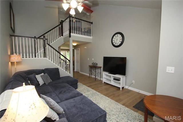 1209 Hunters Chase Dr, Eureka, MO 63025 - living room with wood finished floors, stairway, ceiling fan, baseboards, and high vaulted ceiling