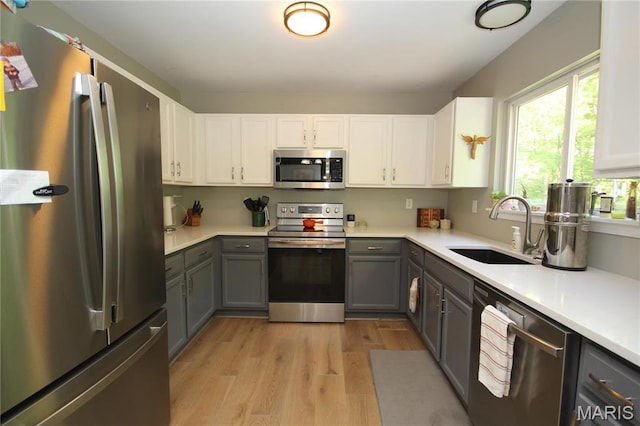 1209 Hunters Chase Dr, Eureka, MO 63025 - kitchen featuring appliances with stainless steel finishes, a sink, gray cabinets, light wood-style floors, and light countertops