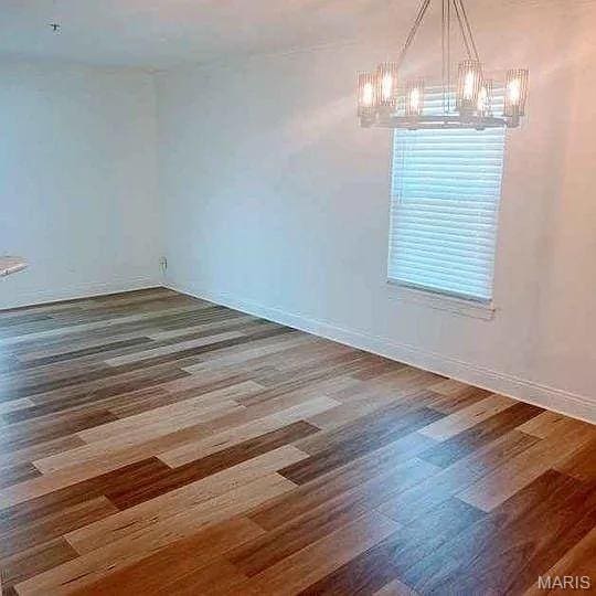 14 Homefield Gardens Dr Unit 19N, Ofallon, MO 63366 - spare room with a chandelier, wood finished floors, and baseboards