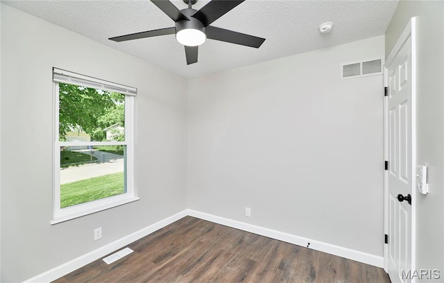 empty room with baseboards, dark wood-style flooring, ceiling fan, a textured ceiling, and a smoke detector