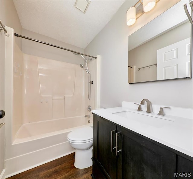 bathroom with wood finished floors, vanity, toilet, and shower / bath combination