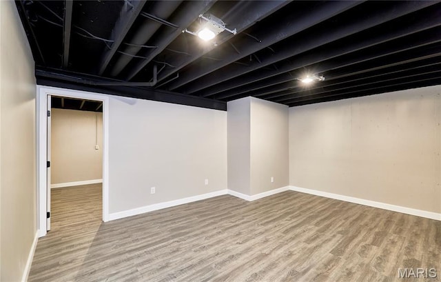 finished basement featuring wood finished floors and baseboards