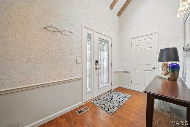 entrance foyer with wood finished floors, baseboards, and a textured wall