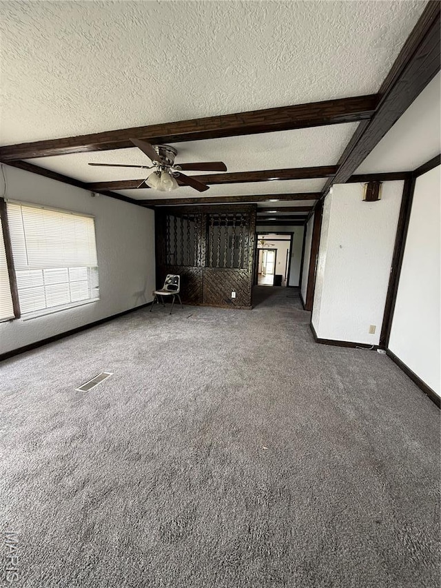 226 Dixie St, Sikeston, MO 63801 - unfurnished living room featuring a textured ceiling, beam ceiling, carpet flooring, ceiling fan, and baseboards