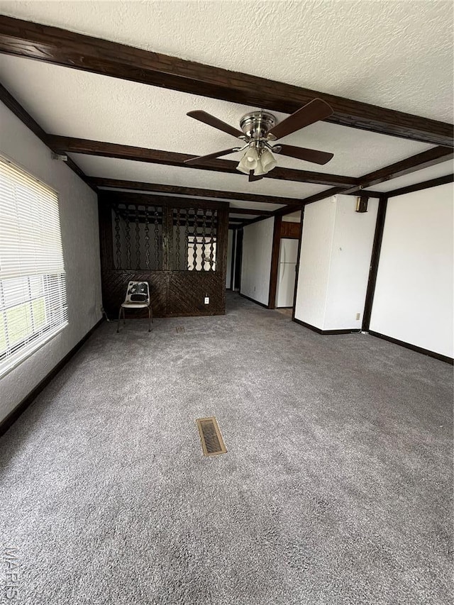 226 Dixie St, Sikeston, MO 63801 - unfurnished living room with ceiling fan, a textured ceiling, carpet flooring, and beam ceiling
