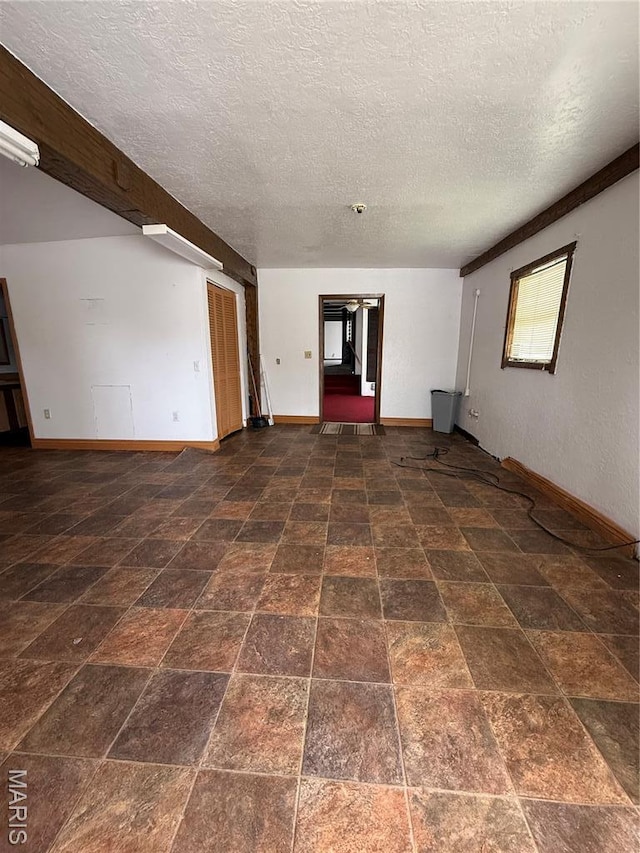 226 Dixie St, Sikeston, MO 63801 - spare room featuring baseboards, a textured ceiling, and stone finish flooring