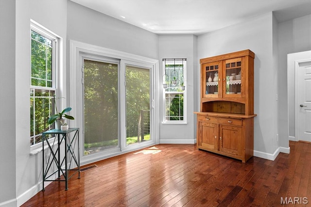 1438 Arbor Green Trl, Ofallon, IL 62269 - unfurnished dining area with healthy amount of natural light, dark wood-style floors, and baseboards