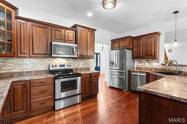 1438 Arbor Green Trl, Ofallon, IL 62269 - kitchen featuring appliances with stainless steel finishes, a sink, dark wood-style floors, glass insert cabinets, and backsplash
