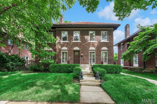 316 Melville Ave, Saint Louis, MO 63130 - georgian-style home with a front yard, a chimney, a tiled roof, and brick siding