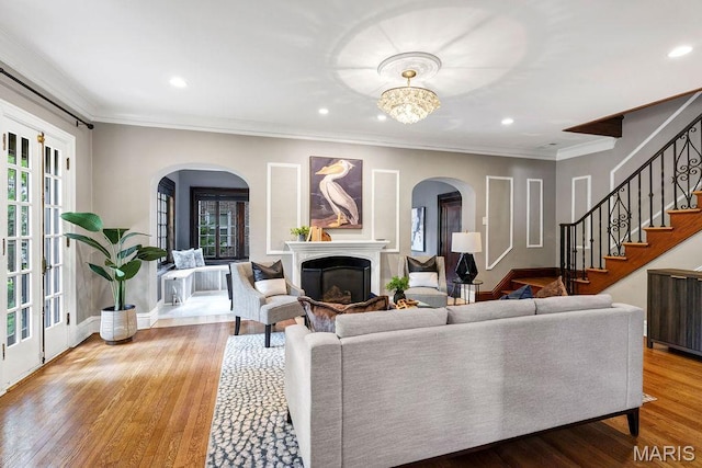 316 Melville Ave, Saint Louis, MO 63130 - living room with arched walkways, stairway, a glass covered fireplace, recessed lighting, and wood finished floors