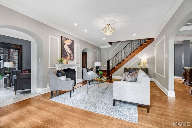 316 Melville Ave, Saint Louis, MO 63130 - living room with wood finished floors, a fireplace, stairs, arched walkways, and recessed lighting