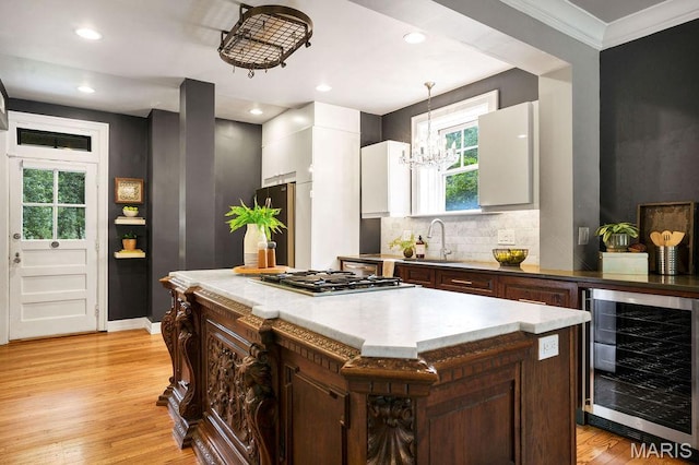 316 Melville Ave, Saint Louis, MO 63130 - kitchen featuring beverage cooler, a sink, ornamental molding, appliances with stainless steel finishes, and a chandelier