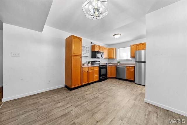 1811 Gascony Parc Dr Unit 1811, Lake St Louis, MO 63367 - kitchen featuring black appliances, baseboards, light wood-style floors, light countertops, and a chandelier