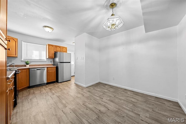 1811 Gascony Parc Dr Unit 1811, Lake St Louis, MO 63367 - kitchen with stainless steel appliances, light wood-type flooring, light countertops, baseboards, and pendant lighting