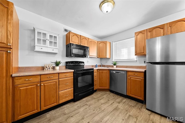 1811 Gascony Parc Dr Unit 1811, Lake St Louis, MO 63367 - kitchen featuring black appliances, light wood-style flooring, light countertops, and brown cabinetry