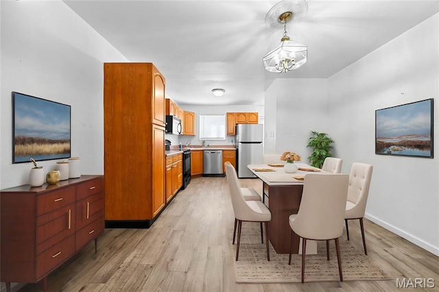 1811 Gascony Parc Dr Unit 1811, Lake St Louis, MO 63367 - dining room featuring a chandelier, light wood finished floors, and baseboards