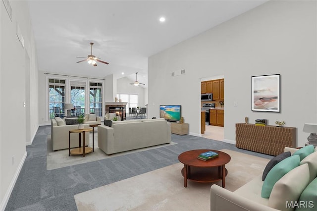 1204 Cobblestone Ter, Lake St Louis, MO 63367 - living room featuring light carpet, a ceiling fan, baseboards, high vaulted ceiling, and recessed lighting