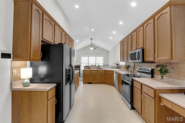 1204 Cobblestone Ter, Lake St Louis, MO 63367 - kitchen featuring appliances with stainless steel finishes, lofted ceiling, a ceiling fan, light countertops, and backsplash