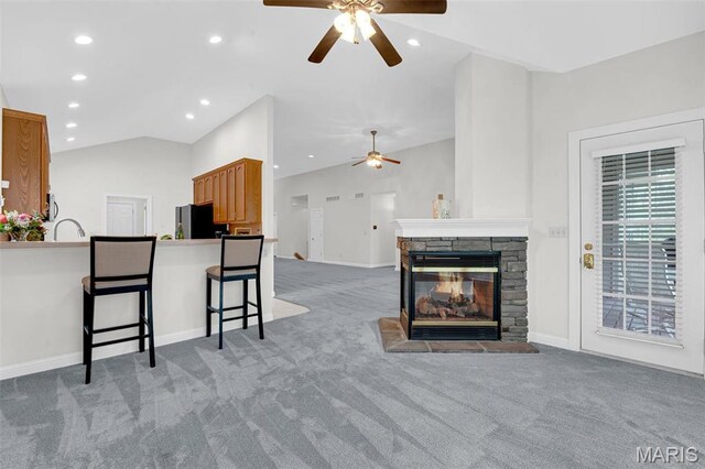 1204 Cobblestone Ter, Lake St Louis, MO 63367 - living room featuring a ceiling fan, carpet flooring, vaulted ceiling, recessed lighting, and a stone fireplace