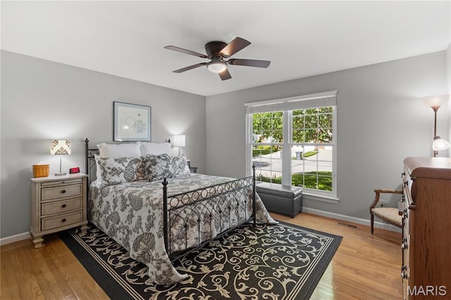 bedroom featuring wood finished floors, baseboards, and ceiling fan