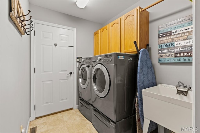 clothes washing area with independent washer and dryer and cabinet space