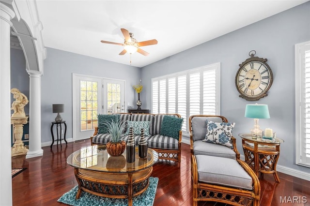 living area featuring a ceiling fan, ornate columns, and wood-type flooring