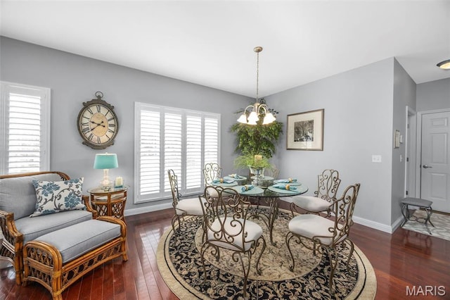 dining room featuring wood-type flooring, a chandelier, and baseboards