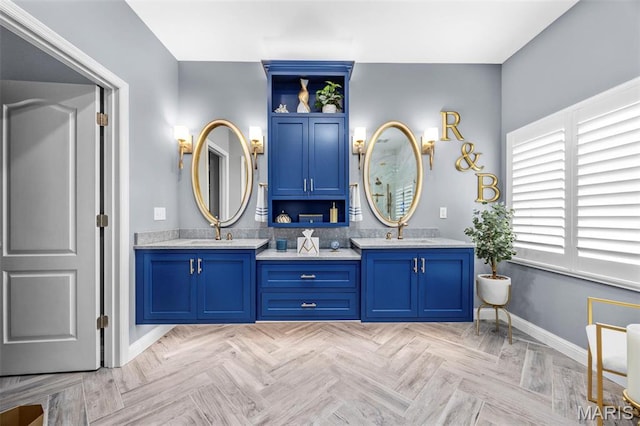 bathroom with baseboards and double vanity